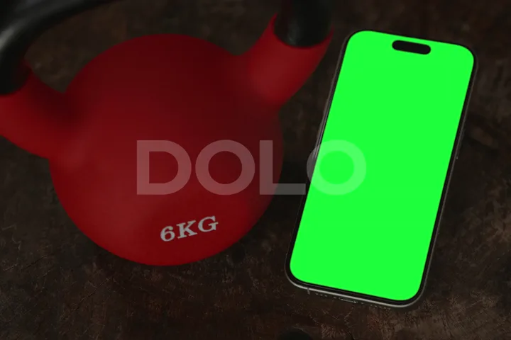 Smartphone Green Screen Beside a Red Kettlebell